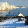 slides/Coast Guards in Snow.jpg coast guard cottages east sussex coastal coast blue sky winter sunny seaside snow cold bitter panoramic cliffs white lighthouse seven sisters country park cuckmere haven river beach Coast Guards in Snow